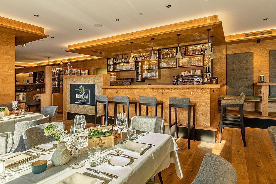 Stilvoll gedeckte Tische vor einer Bar im Hotel Kaltenbach in Tirol 