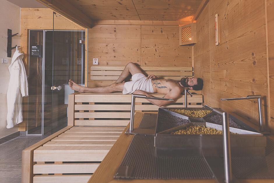 Hotelgast entspannt sich in einer Holzsauna im Wellnesshotel Tirol 