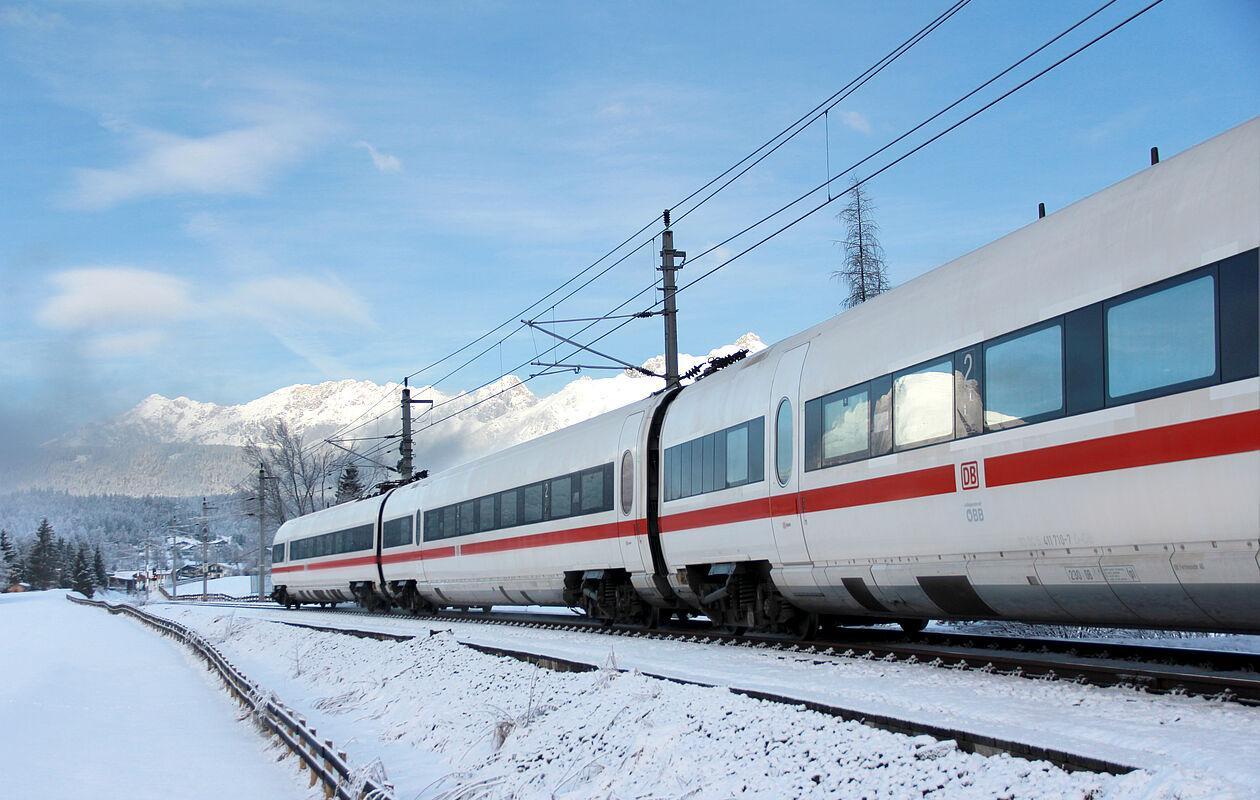 Schnellzug fährt durch die schneebedeckte Landschaft in Österreich 