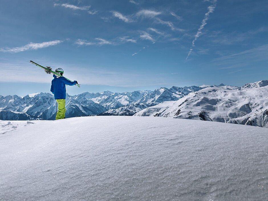 Skifahrer blickt auf schneebedeckte Berge in der Zillertal Region 