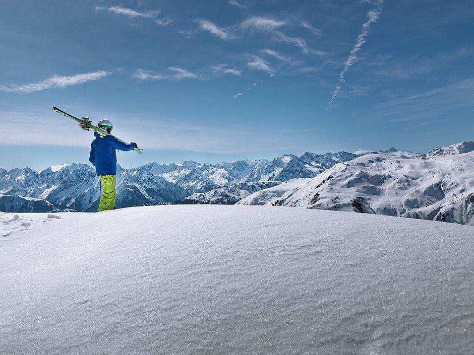 Skifahrer blickt auf schneebedeckte Berge in der Zillertal Region