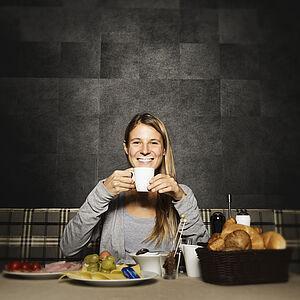 Dame genießt das Frühstücksbuffet im Hotel Kaltenbach mit einer Tasse Kaffee 