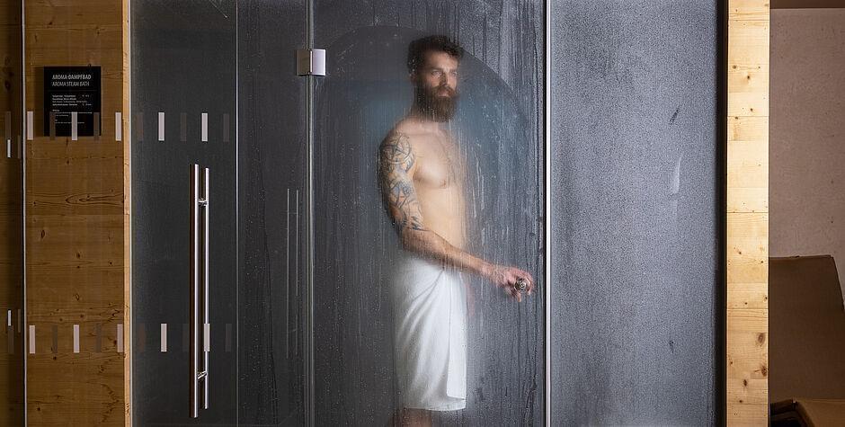 Hotelgast steht in der Dusche des Wellnesshotels in Tirol 