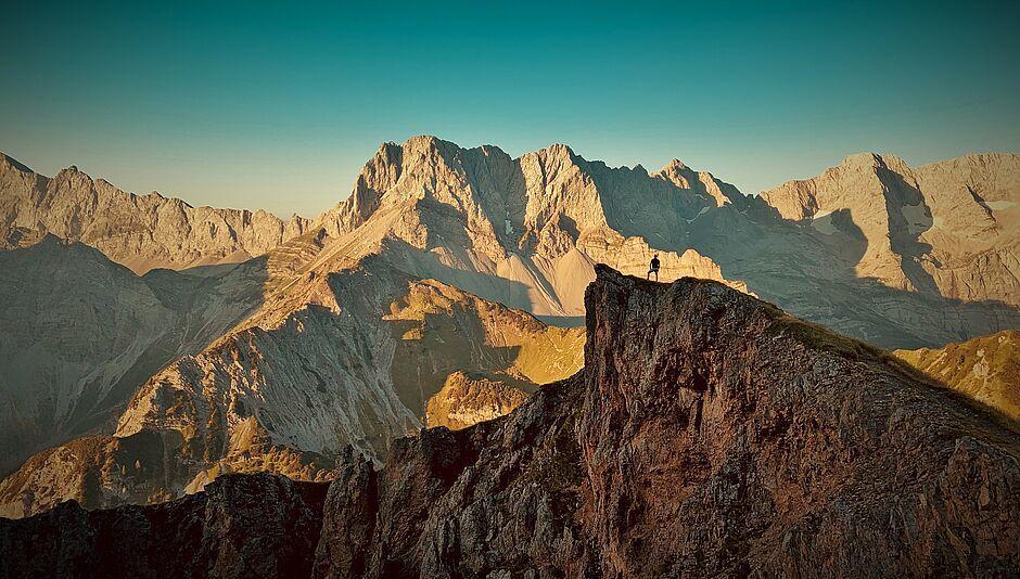 Luftaufnahme einer Gebirgskette in Österreich bei Sonnenaufgang 
