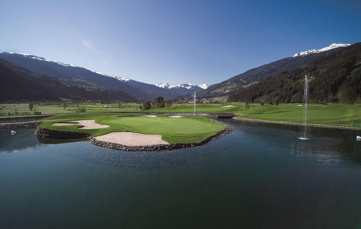 Aktivitäten für den Sommerurlaub in Tirol: Eine Golfanlage mit großem Teich fügt sich idyllisch in die Landschaft des Zillertals ein