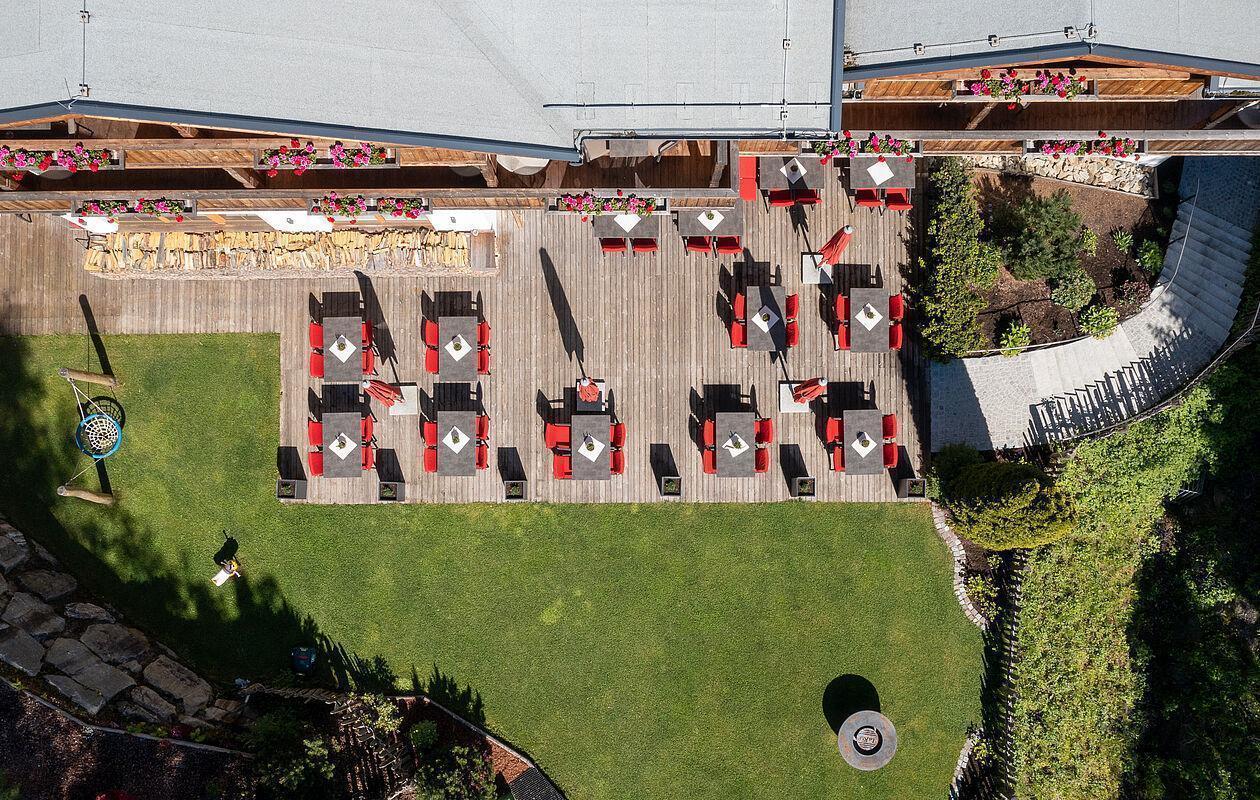 Blick auf die eingedeckte Frühstücksterrasse des Hotels bei Sonnenschein