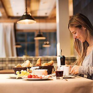 Dame genießt das reichliche Frühstück im Restaurant des Naturhotels in Tirol 