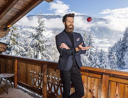 Hotelgast im Anzug steht auf einem Balkon des Naturhotels im Zillertal