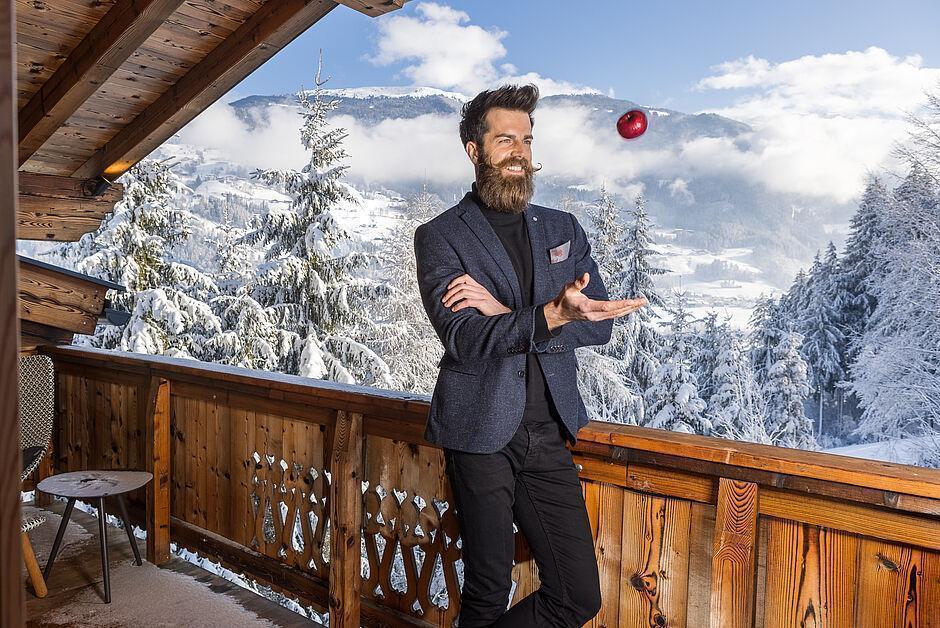Hotelgast im Anzug steht auf einem Balkon des Naturhotels im Zillertal 