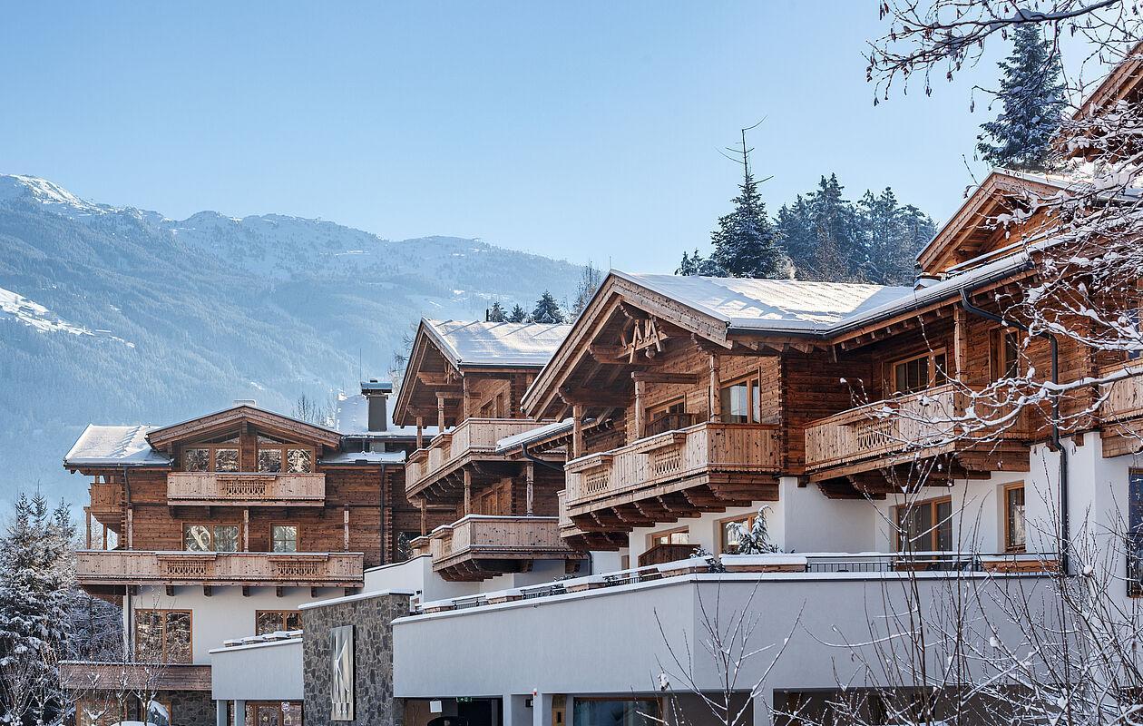 Die hölzerne Fassade des Hotel Kaltenbach im Winter vor beeindruckendem Bergpanorama