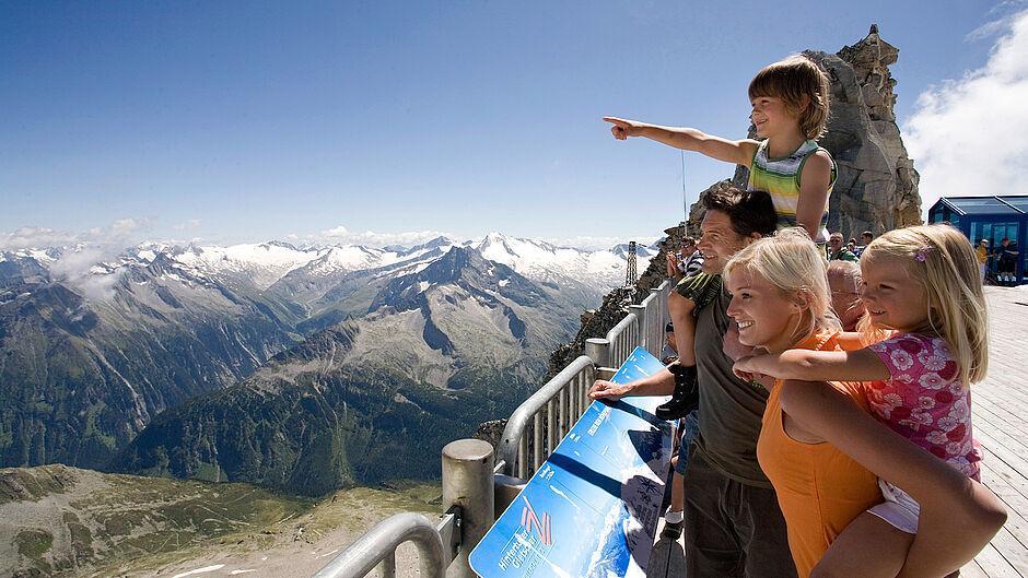 Familie mit kleinen Kindern im Sommer in den Zillertaler Alpen vor einem Bergpanorama 
