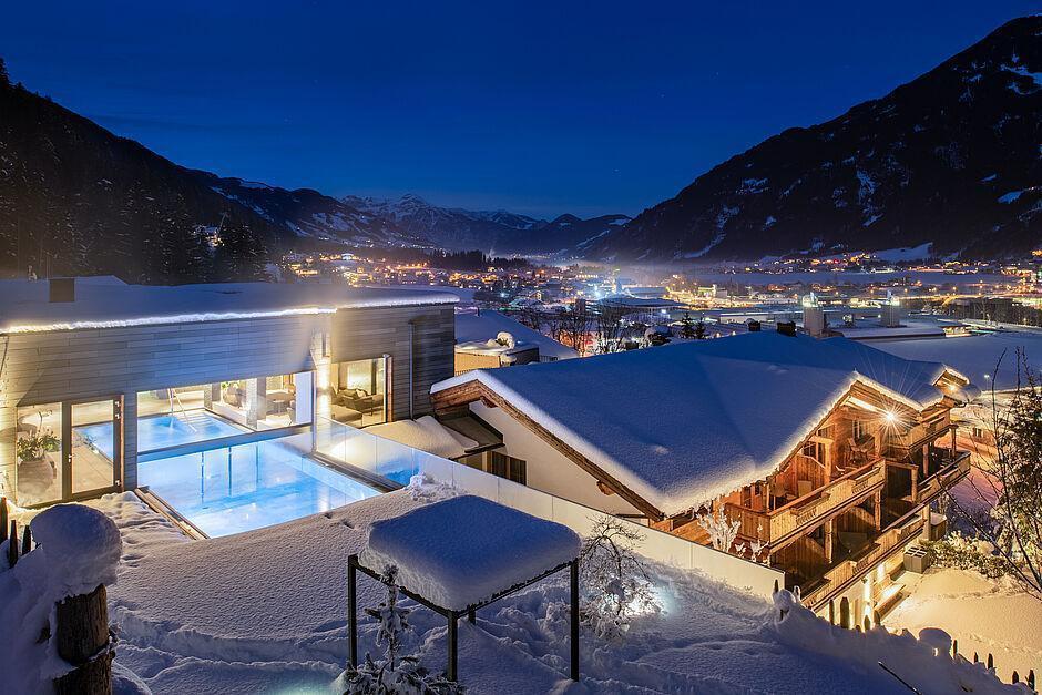 Blick auf das schneebedeckte Hotel mit Spa in Tirol am Abend 
