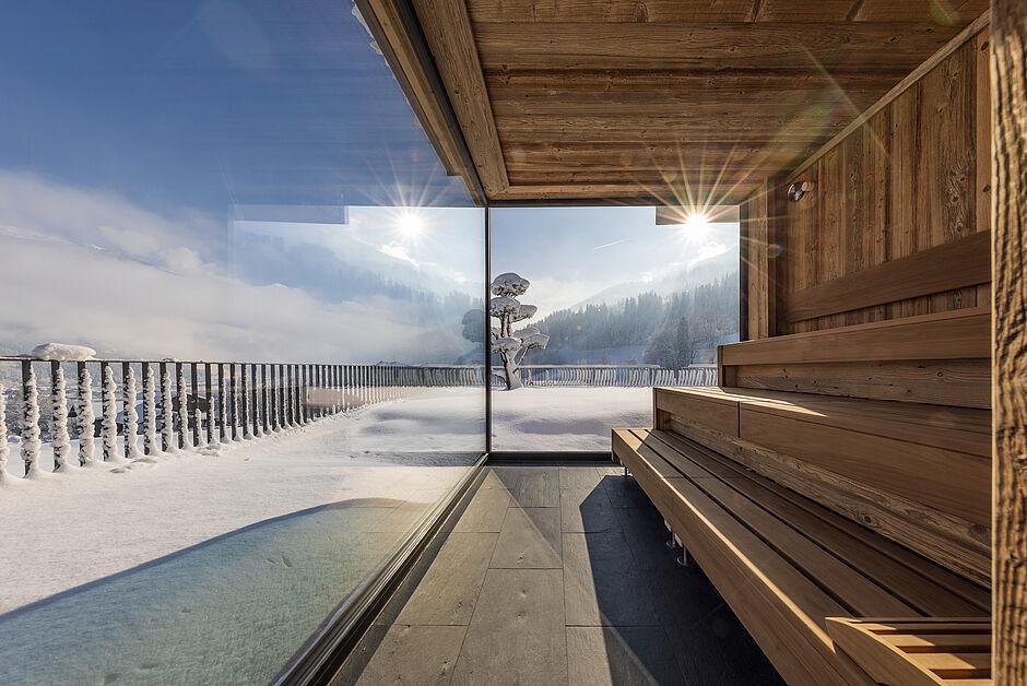 Ausblick aus der Panorama Sauna auf die verschneiten Berge