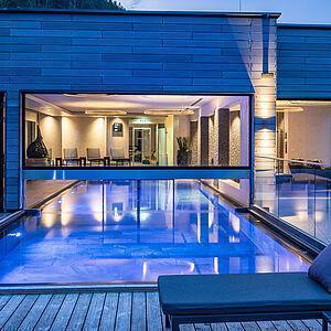 Außenpool mit Beleuchtung im Wellnesshotel Zillertal am Abend 