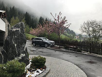 Ein SUV mit Kaltenbach Branding parkt vor dem Hotel