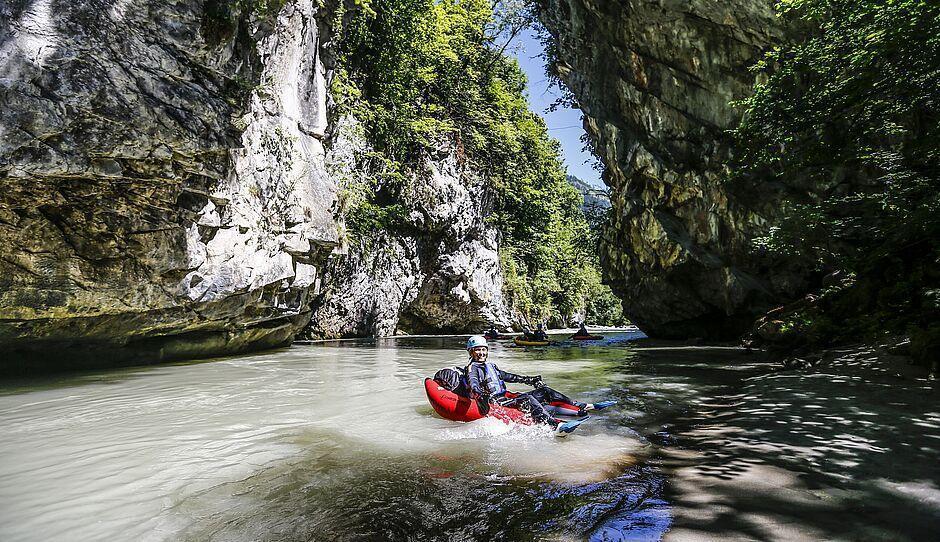 Eine Frau in einem kleinen Boot beim Canyoning auf einem Flusslauf im Zillertal