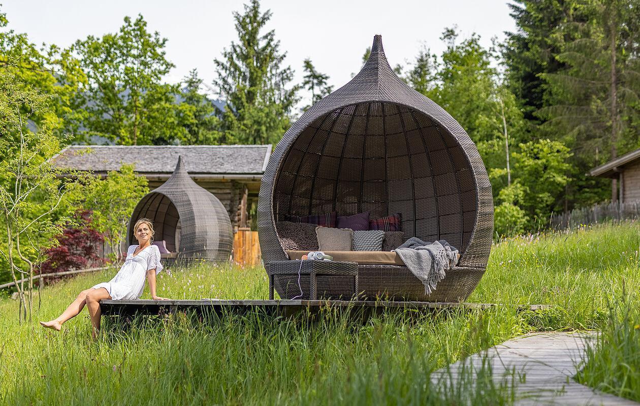 Dame genießt den Tag auf einer Ruheplattform im Wellnesshotel Tirol 