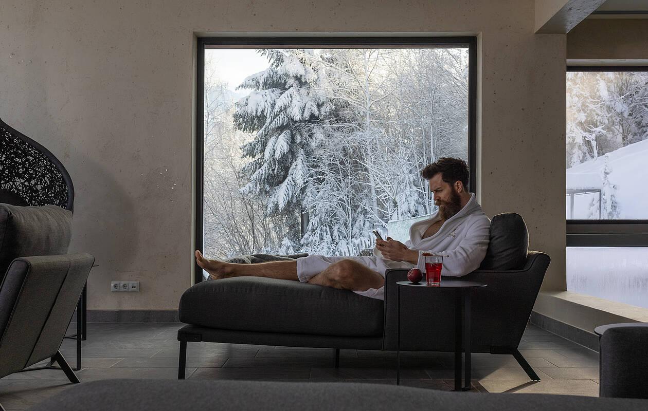 Hotelgast entspannt auf einer Liege im Ruhebereich des Wellnesshotel Tirol 
