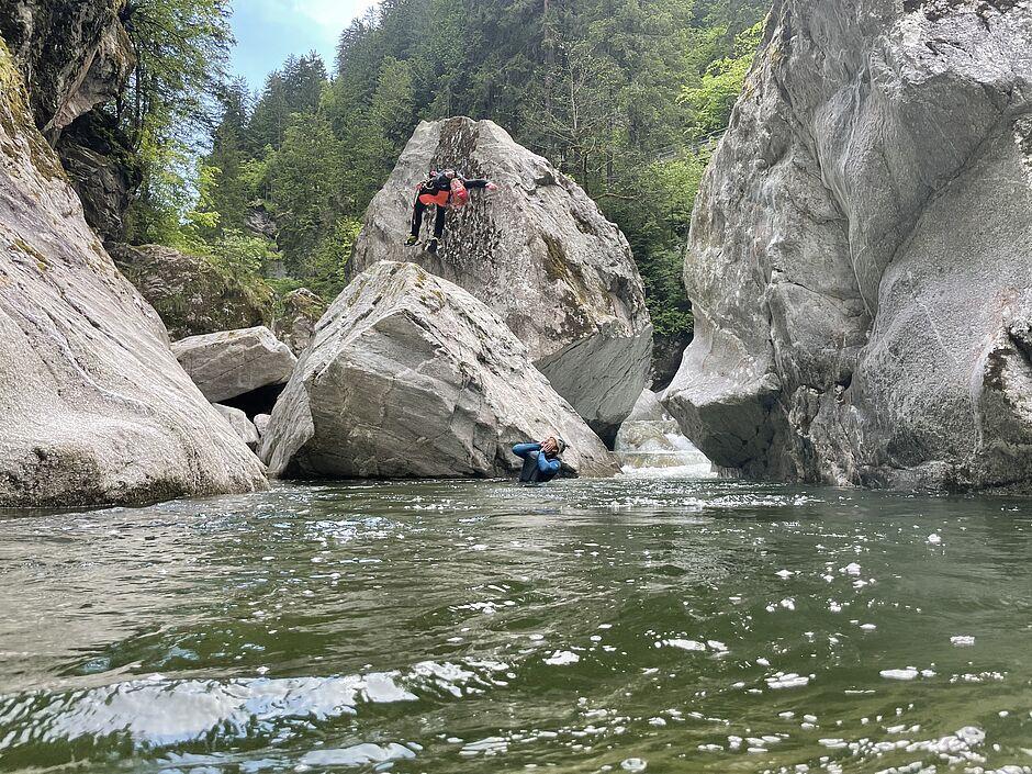 Mann springt von einem Felsen in einen Bergsee nahe des Naturhotels 